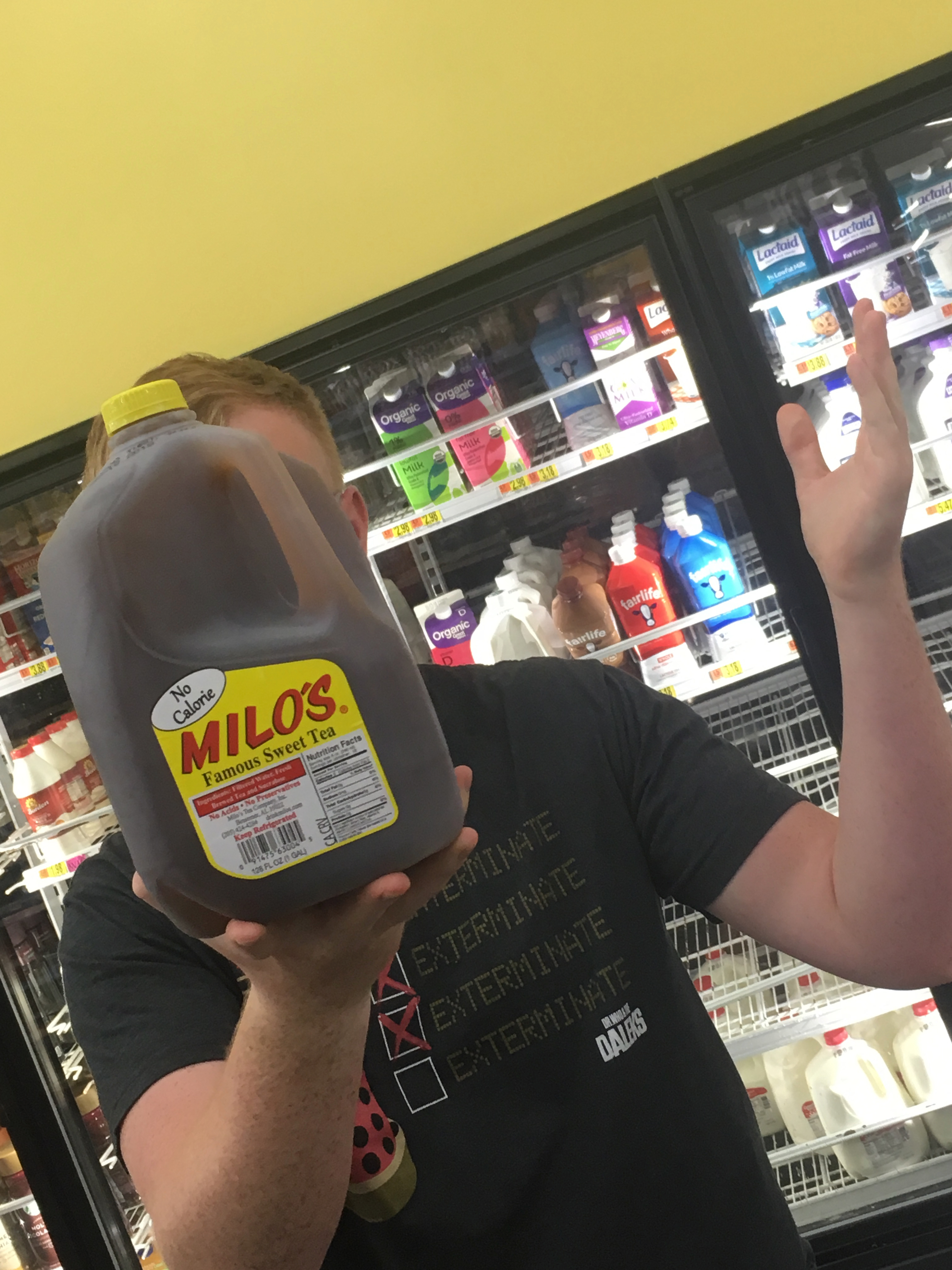 i'm holding a jug of milo's zero calorie sweet tea in front of my face at walmart