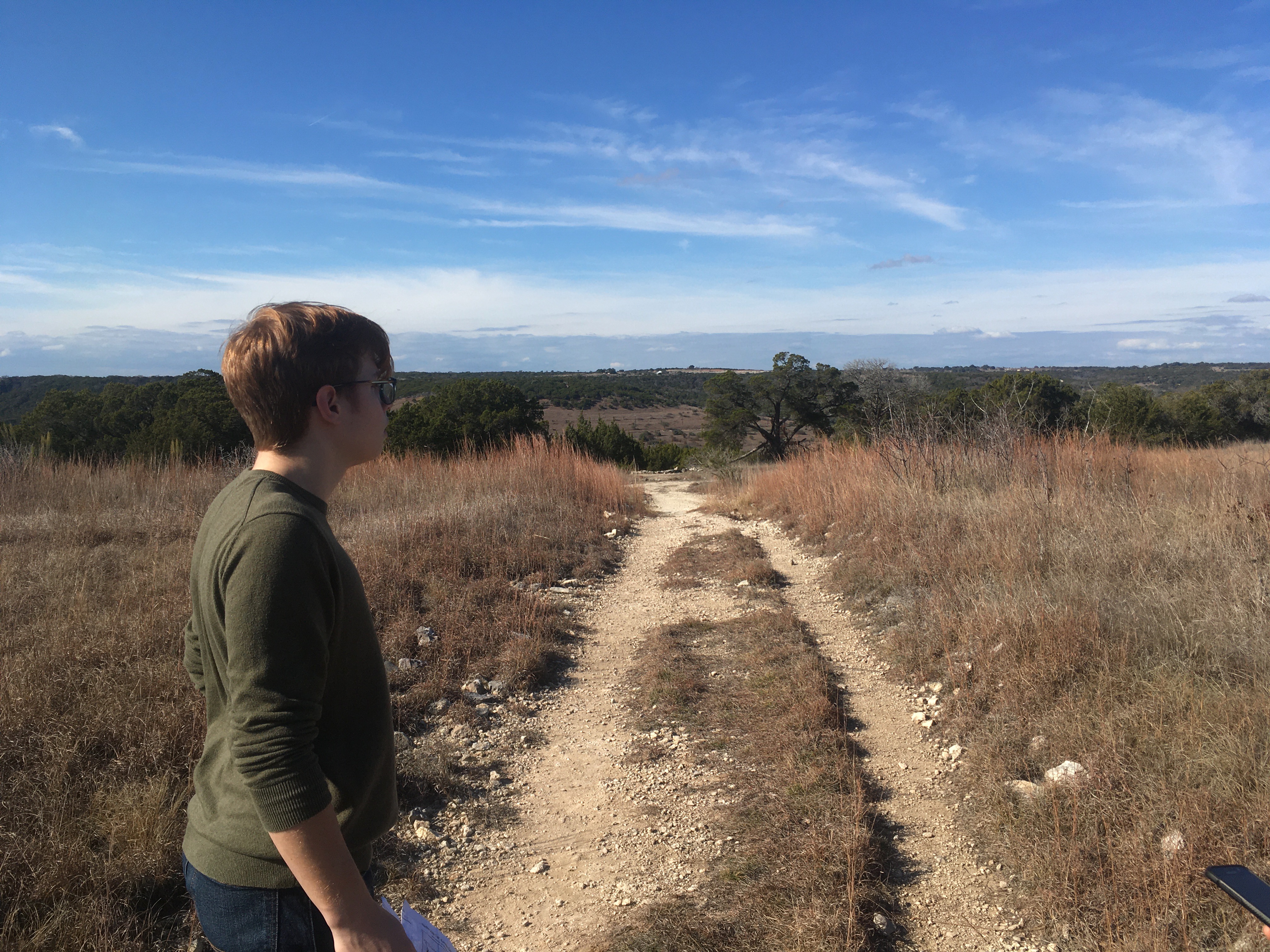 my brother staring into the void, with a gravel path going off into the distance